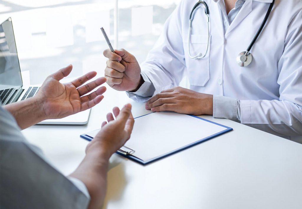 Médecin avec un stéthoscope discutant avec un patient