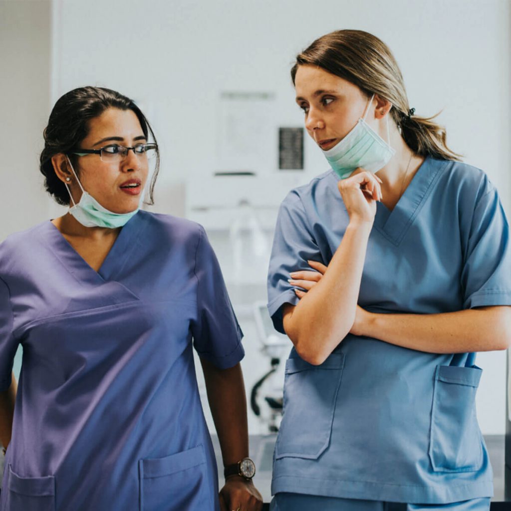 Deux médecins en blouse bleue discutant